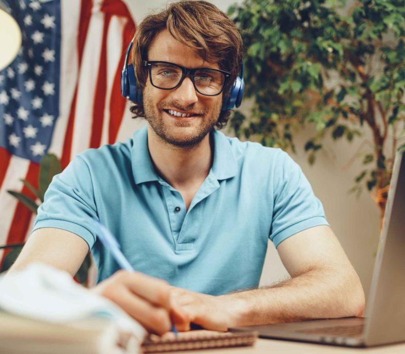 young-bearded-businessman-sitting-table-with-laptop-american-flag (1)